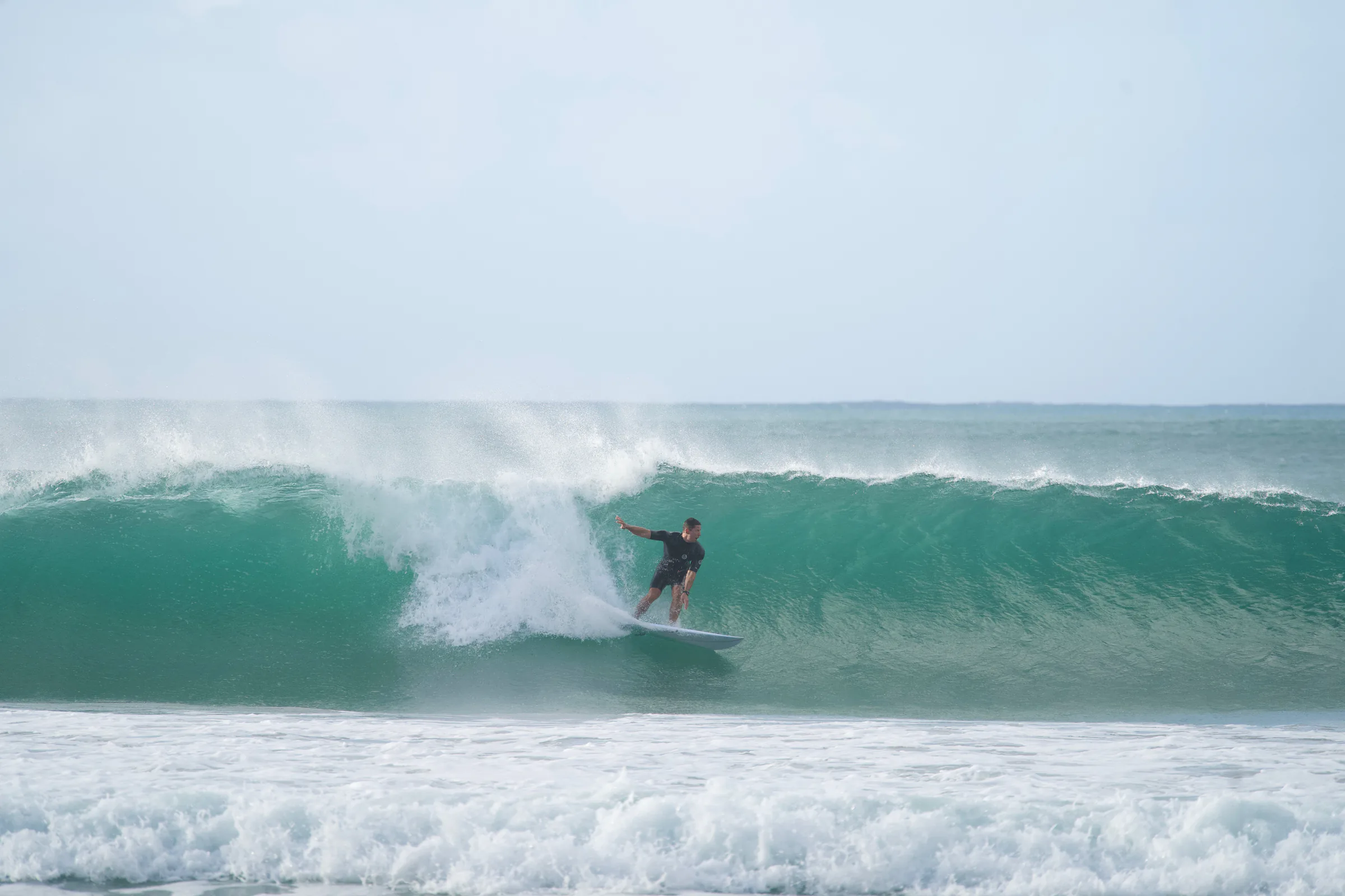 A surfer carving through a glassy green wave